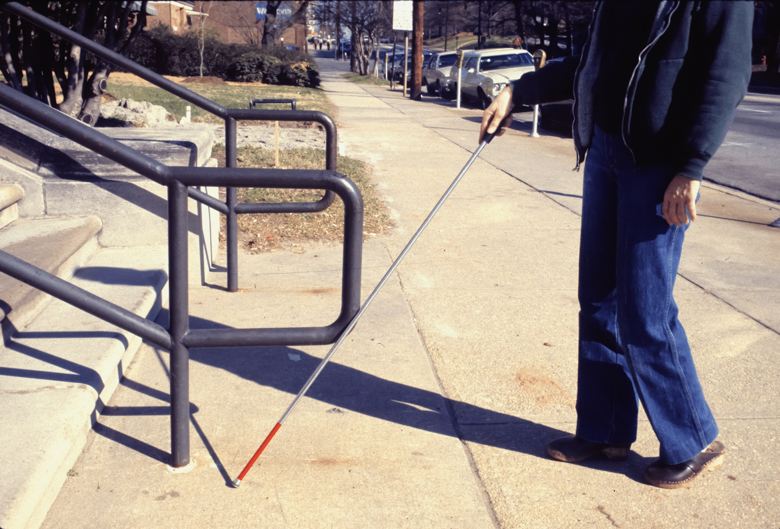 A picture of a blind person using a walking stick.